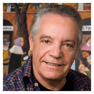 Smiling man in front of colorful mural.