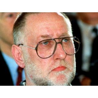 Man with glasses and beard at event.