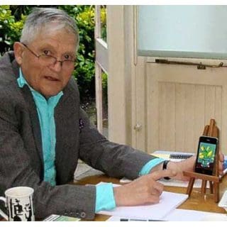 Man pointing at smartphone on small easel.