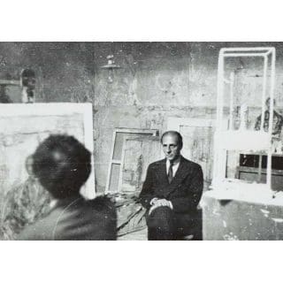 Man seated in an art studio setting.