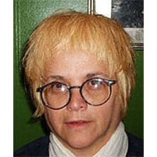 Person with short blond hair and glasses.