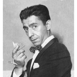 Man in suit holding a cocktail glass.